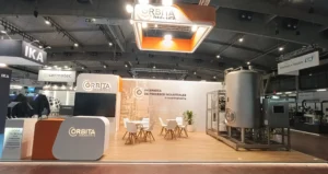 Stand a medida de Órbita Ingeniería en Expoquimia 2026 con estructura aérea de rigging suspendida