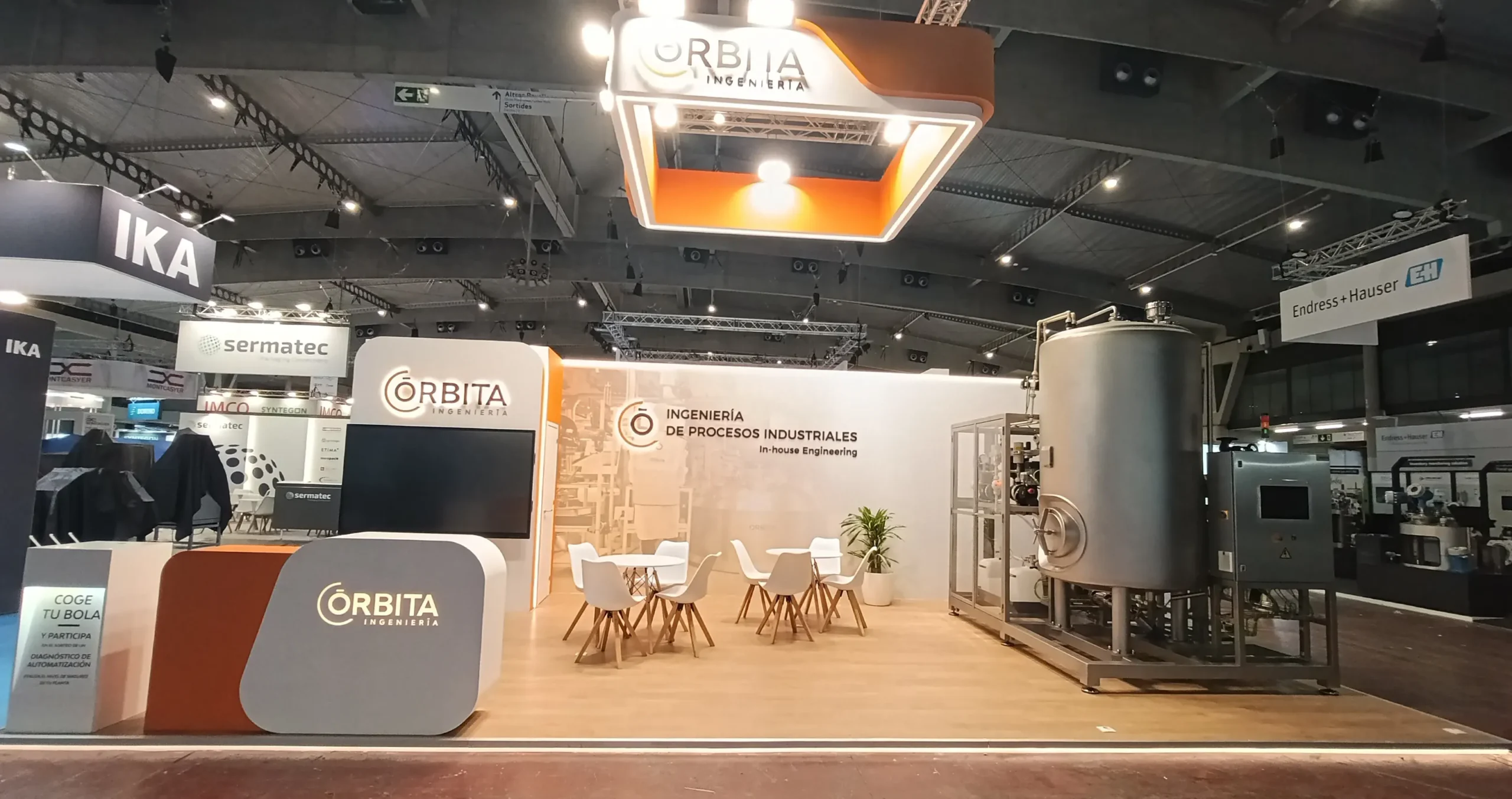 Stand a medida de Órbita Ingeniería en Expoquimia 2026 con estructura aérea de rigging suspendida